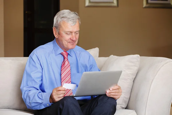 Senior man sitting at sofa — Stock Photo, Image