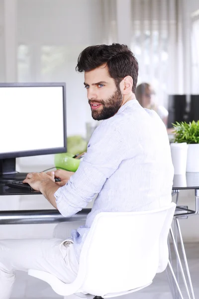 Casual affärsman sitter vid skrivbord — Stockfoto