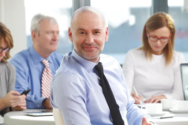 Senior businessman sitting at business meeting — 스톡 사진