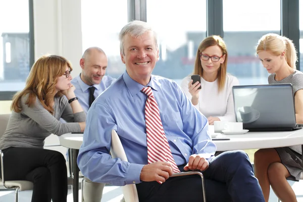 Senior businessman sitting at business meeting — Stock fotografie