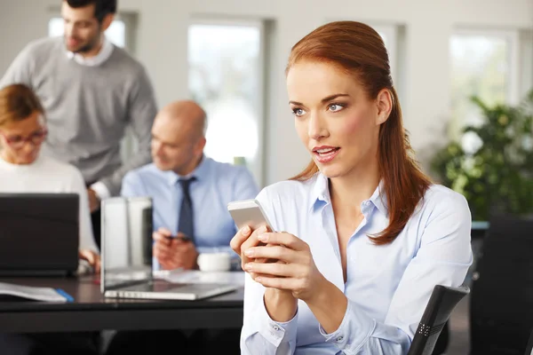 Attractive businesswoman sitting at office — Stock Photo, Image