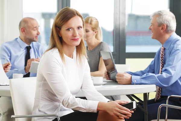 Smiling businesswoman sitting at meeting — Stockfoto