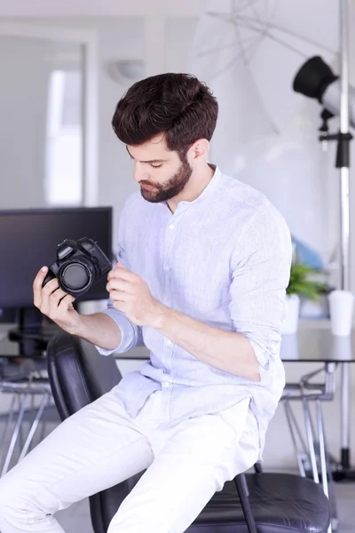 Junge Fotografin sitzt im Studio — Stockfoto