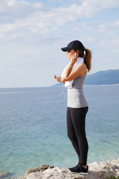 Fit female standing at seaside after running — Stock Photo, Image