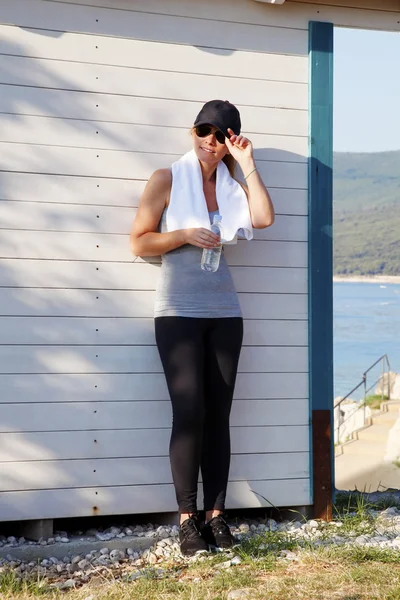 Fit female standing at seaside after running — Stock Photo, Image