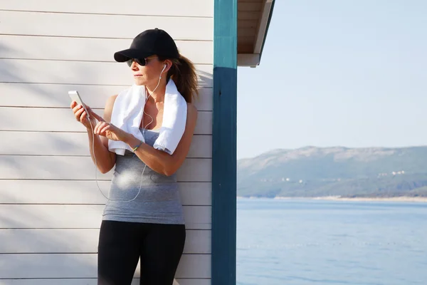 Fit female standing at seaside after running — Stock Photo, Image