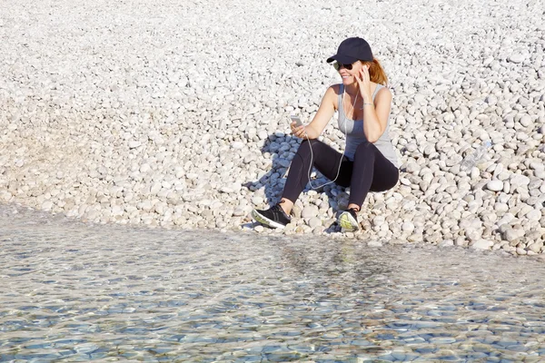 Fit woman with earphone listening music — Stock Photo, Image