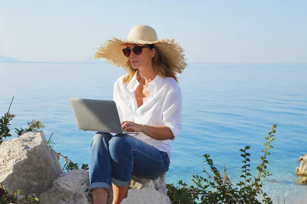 Casual zakenvrouw werken door zee — Stockfoto