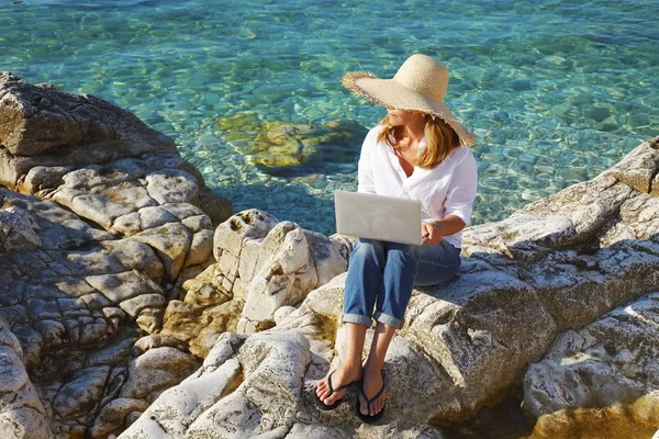 Casual vrouw die werkt door zee — Stockfoto