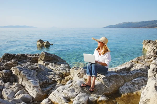 Femme d'affaires occasionnelle travaillant par la mer — Photo