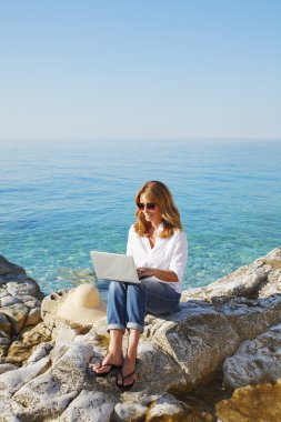 woman by see using personal computer