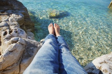 woman with bared feet relaxing at beach
