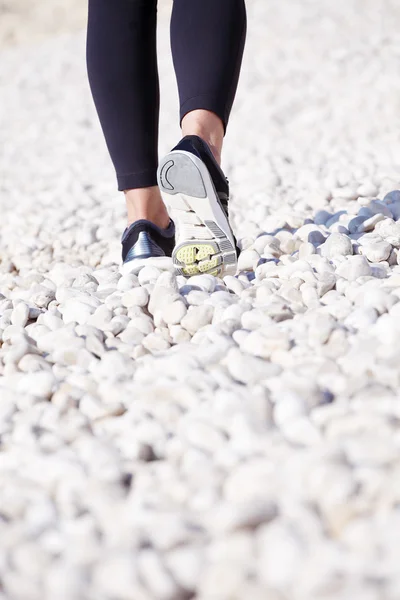 Woman after morning run walking on beach — Stockfoto