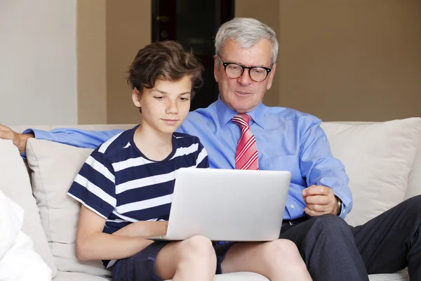 Menino de ensino avô usar laptop — Fotografia de Stock