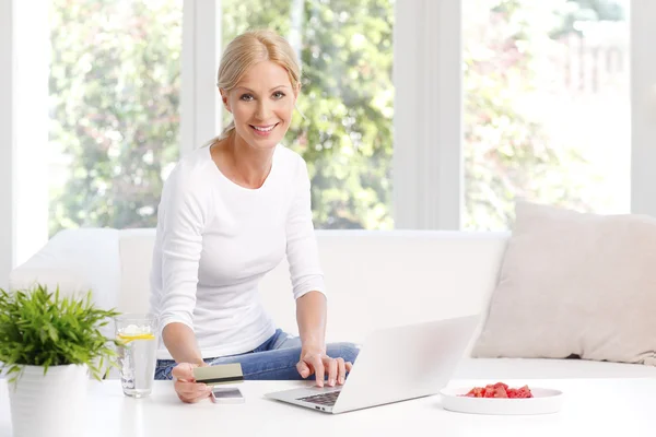 Vrouw zitten op de Bank online winkelen — Stockfoto