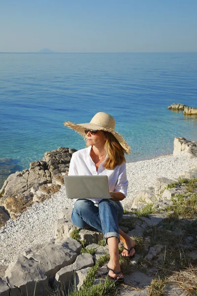 Γυναίκα που εργάζεται με το laptop στην παραλία — Φωτογραφία Αρχείου