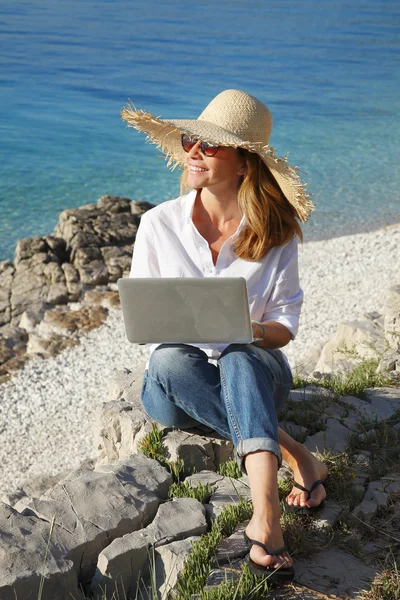 Γυναίκα που εργάζεται με το laptop στην παραλία — Φωτογραφία Αρχείου