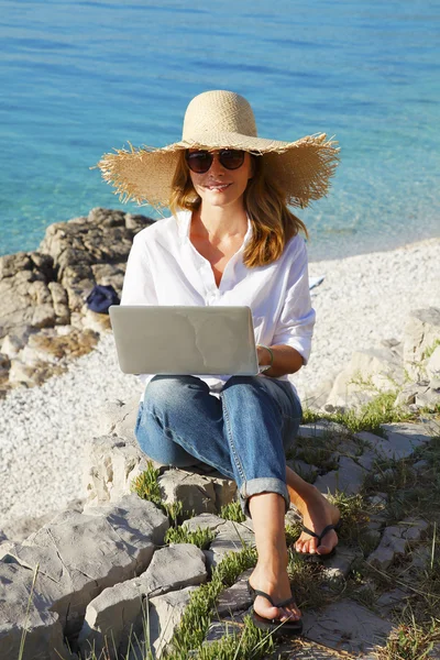 Zakenvrouw door zee werken online met laptop — Stockfoto