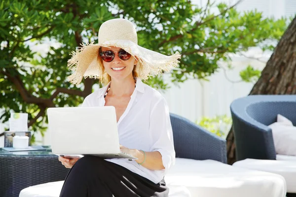 Mulher no jardim e trabalhando laptop online — Fotografia de Stock