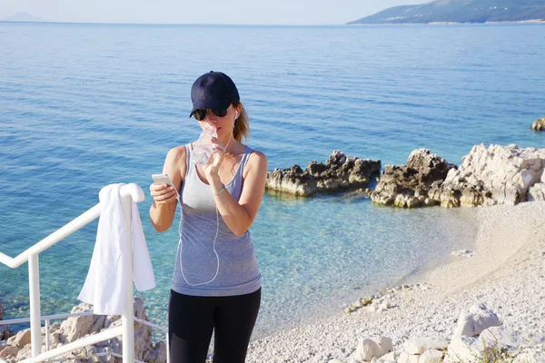 Woman standing at seaside after workout — Stock Photo, Image