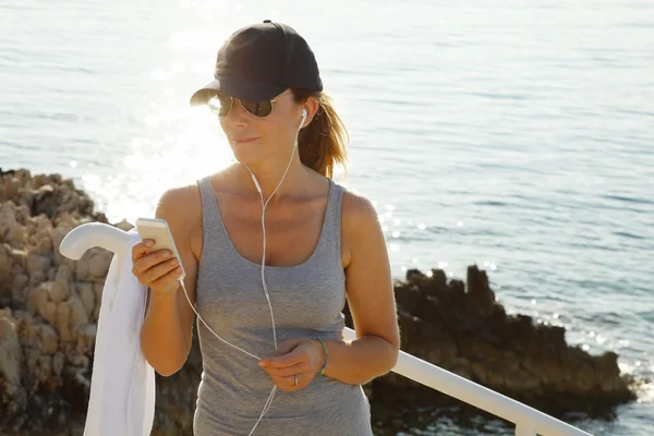 Woman standing at seaside after workout — Stock Photo, Image