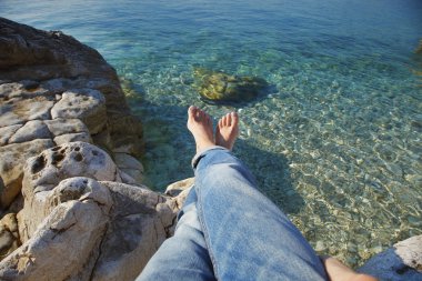 woman with bared feet relaxing at beach