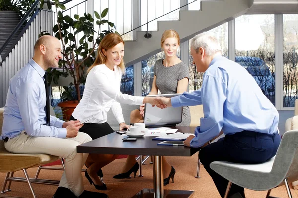 Businesswoman shaking hands with senior businessman — Stock Photo, Image