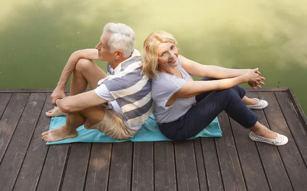 Pareja mayor sentada en el muelle — Foto de Stock