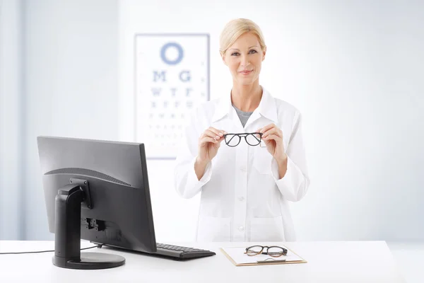 Optometrist doctor standing ad desk — Stock Photo, Image