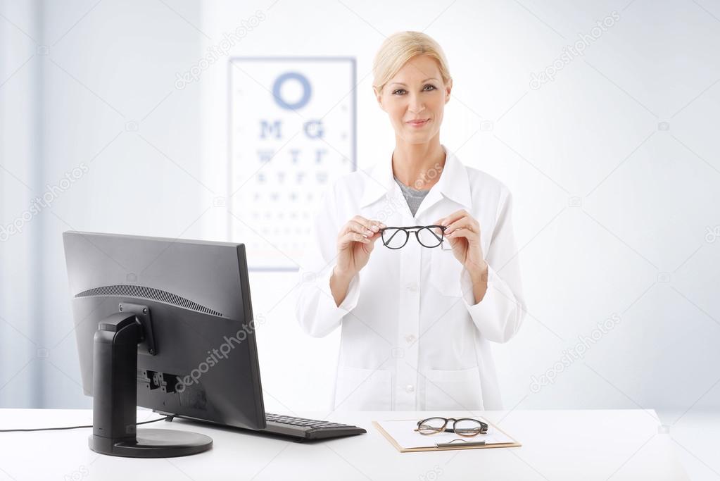 optometrist doctor standing ad desk