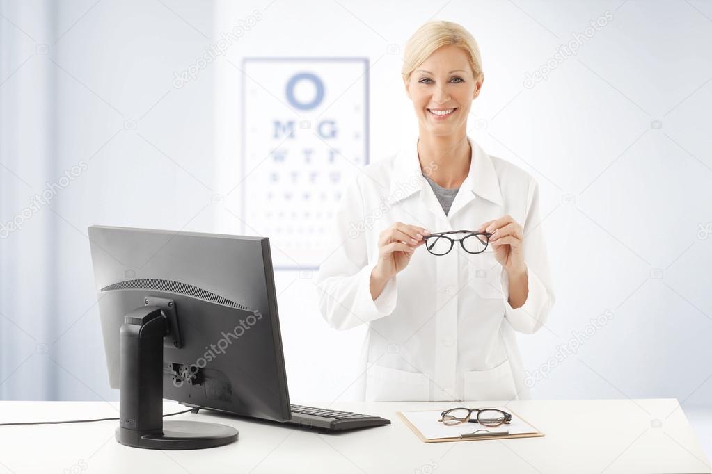 optometrist doctor standing ad desk