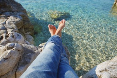 woman with bared feet relaxing at beach