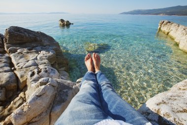 woman with bared feet relaxing at beach