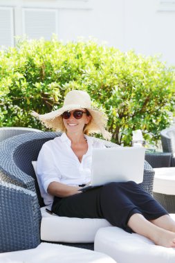 Garden'da laptop ile oturan kadın