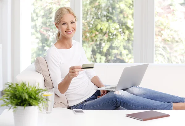 Woman sitting at sofa in front of laptop — Stok fotoğraf