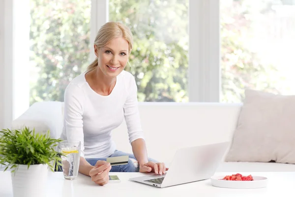 Mulher sentada no sofá na frente do laptop — Fotografia de Stock