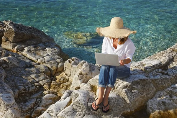 Woman with laptop sitting on the beach — Φωτογραφία Αρχείου