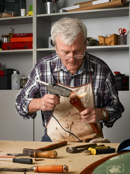 Rentner arbeitet in seiner Werkstatt — Stockfoto