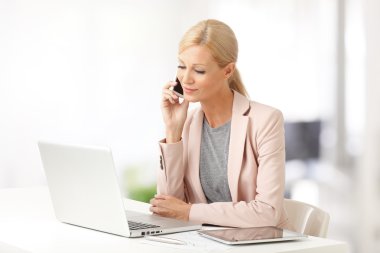 woman making call while sitting at office