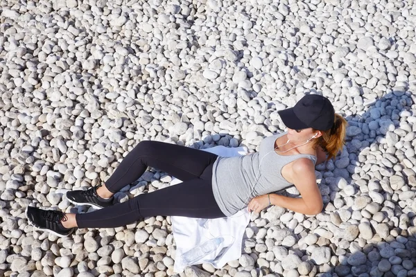 Woman lying on beach after morning workout — Stock Photo, Image