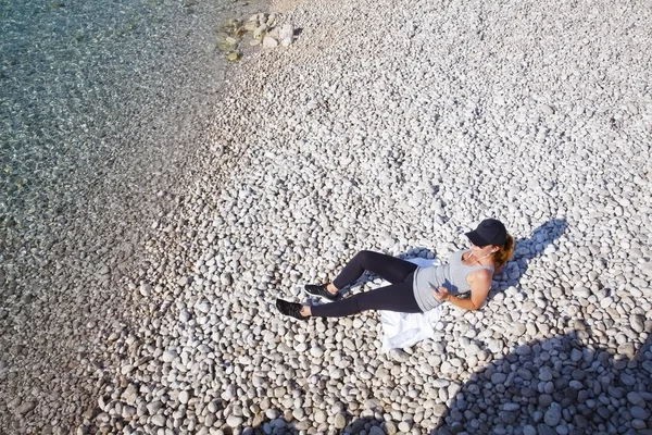 Woman lying on beach after morning workout — Stock Photo, Image