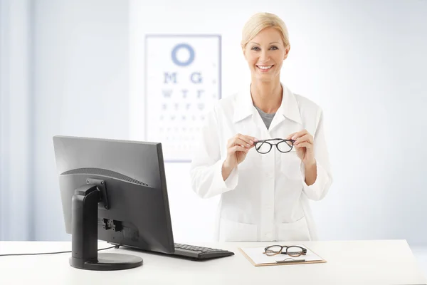 Médico feminino segurando óculos de mão — Fotografia de Stock