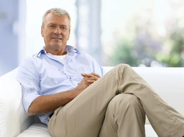 Old man sitting at sofa at home — Stock fotografie