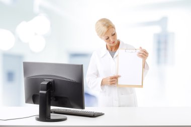 female physician standing in front of computer