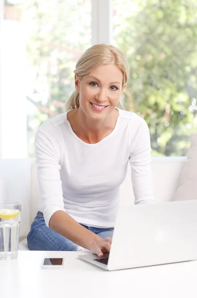 Woman checking emails and working on laptop — Stockfoto