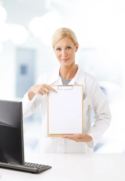 Health care worker holding clipboard — Stockfoto