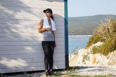 Kadın elinde bir şişe su tutuyor.