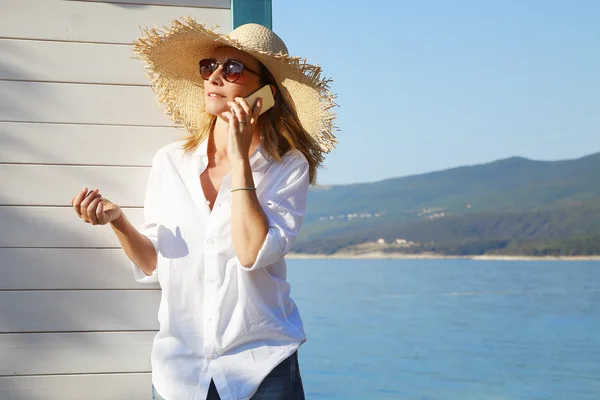 Woman by beach house and making call — Stock Photo, Image