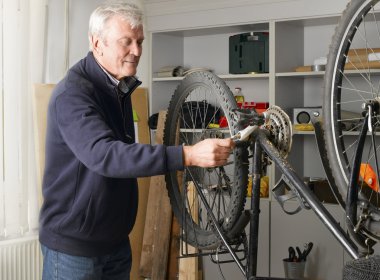 man standing at workshop and repairs bike