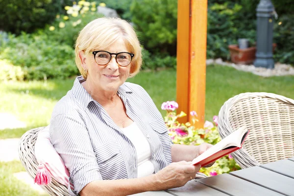 Senior woman enjoying a good book — Stok fotoğraf